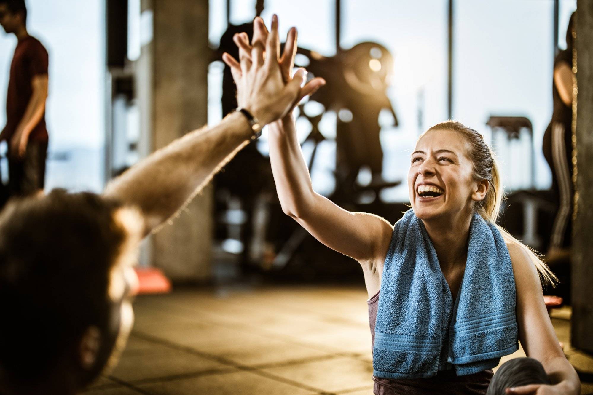 Happy athletic woman giving high-five to her friend on a break in a gym. Happy athletic woman giving high-five to her friend on a break in a gym.