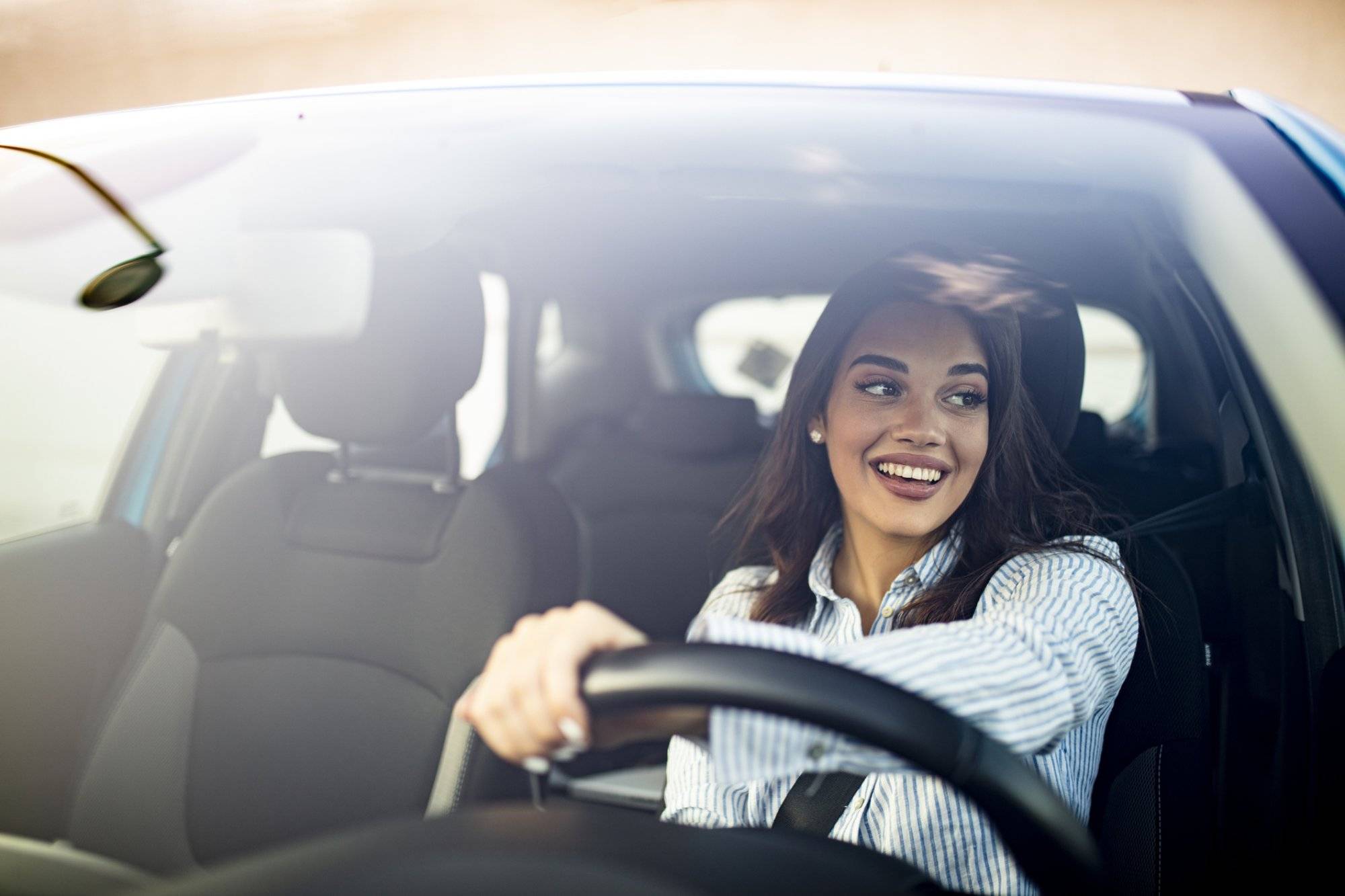 Cute young success happy brunette woman is driving a car. Cute young success happy brunette woman is driving a car.