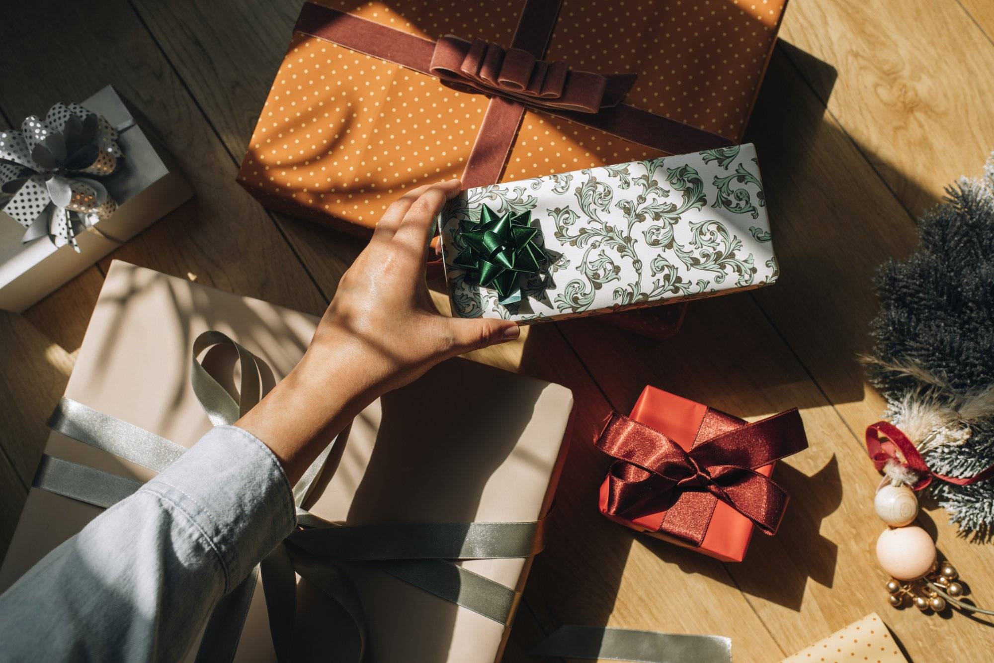 Hand of a Woman Holding a Wrapped Christmas Present, an Overhead View Shop Last Minute Christmas Gifts in Dallas at Mervyn’s Plaza